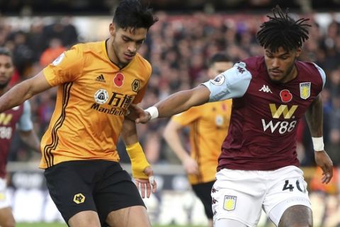 Wolverhampton Wanderers' Raul Jimenez, centre, vies for the ball with Aston Villa's Tyrone Mings, right, during the English Premier League soccer match between Wolverhampton Wanderers and Aston Villa, at Molineux, in Wolverhampton, England, Sunday, Nov. 10, 2019. (Nick Potts/PA via AP)