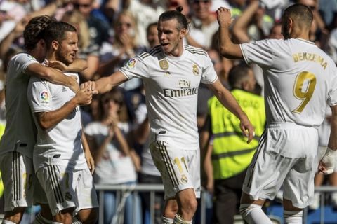 Real Madrid's Eden Hazard, second left, is congratulated by teammates after scoring during the Spanish La Liga soccer match between Real Madrid and Granada at the Santiago Bernarbeu stadium in Madrid, Saturday, Oct. 5, 2019. (AP Photo/Bernat Armangue)
