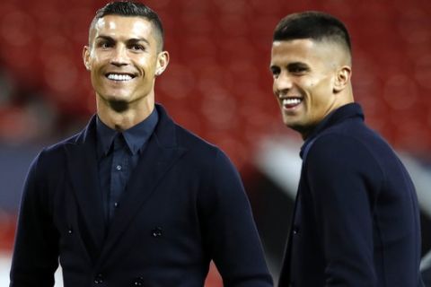 Juventus' Cristiano Ronaldo, left, during the walkaround at Old Trafford, Manchester, England, Monday, Oct. 22, 2018. Juventus will play a Champions League soccer match against Manchester United on Tuesday. (Martin Rickett/PA via AP)