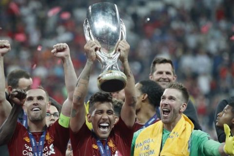 Liverpool's Jordan Henderson, Roberto Firmino and goalkeeper Adrian, from left to right, celebrate with the trophy after winning the UEFA Super Cup soccer match between Liverpool and Chelsea, in Besiktas Park, in Istanbul, Thursday, Aug. 15, 2019. Liverpool won 5-4 in a penalty shootout after the game ended tied 2-2. (AP Photo/Thanassis Stavrakis)