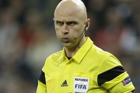 FIFA referee Sergei Karasev holds a whistle during a Champions League round of 16, second leg, soccer match between Real Madrid and Schalke 04 at the Santiago Bernabeu stadium in Madrid, Tuesday March 18, 2014. (AP Photo/Paul White)