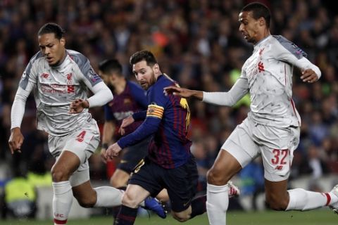 Barcelona's Lionel Messi runs with the ball between Liverpool's Virgil Van Dijk, left, and Joel Matip, right, during the Champions League semifinal, first leg, soccer match between FC Barcelona and Liverpool at the Camp Nou stadium in Barcelona Spain, Wednesday, May 1, 2019. (AP Photo/Joan Monfort)
