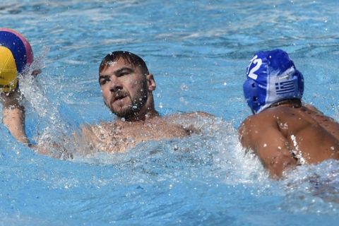 Dusko Pijetlovic, left, of Serbia, and Angelos Vlachopoulos, of Greece, vie for the ball during the men's water polo Group C third round match of the 17th FINA Swimming World Championships in Hajos Alfred National Swimming Pool in Budapest, Hungary, Friday, July 21, 2017. (Balazs Czagany/MTI via AP)