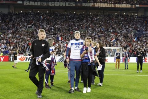 People invade the pitch few minutes before the Europa League quarterfinal soccer match between Lyon and Besiktas, in Decines, near Lyon, central France, Thursday, April 13, 2017. (AP Photo/Laurent Cipriani)
