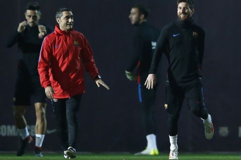 FC Barcelona's coach Ernesto Valverde, second left, talks with Lionel Messi during a training session at the Sports Center FC Barcelona Joan Gamper in Sant Joan Despi, Saturday, Nov 25, 2017. Valencia will play against FC Barcelona in a Spanish La Liga soccer match on Sunday. (AP Photo/Manu Fernandez)