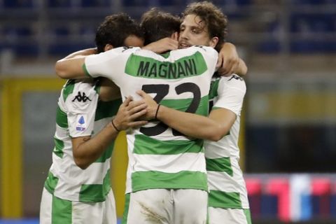 Sassuolo's Giangiacomo Magnani, center, celebrates with his teammates after scoring his side's third goal during the Serie A soccer match between Inter Milan and Sassuolo at the San Siro Stadium, in Milan, Italy, Wednesday, June 24, 2020. (AP Photo/Luca Bruno)
