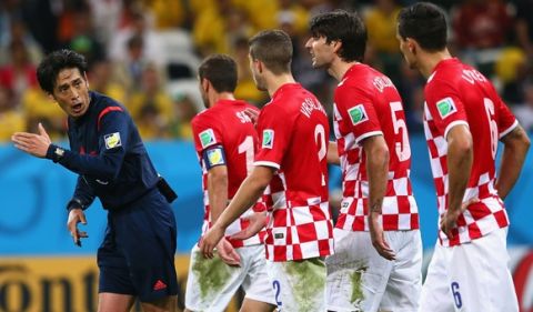 SAO PAULO, BRAZIL - JUNE 12: Referee Yuichi Nishimura is pursued by Darijo Srna, Sime Vrsaljko, Vedran Corluka and Dejan Lovren of Croatia after awarding a penalty kick and giving Lovren a yellow card in the second half during the 2014 FIFA World Cup Brazil Group A match between Brazil and Croatia at Arena de Sao Paulo on June 12, 2014 in Sao Paulo, Brazil.  (Photo by Kevin Cox/Getty Images)