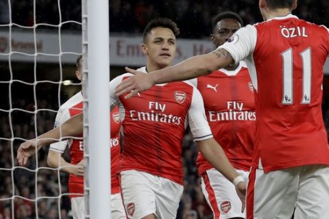 Arsenal's Alexis Sanchez, left, celebrates scoring his side's first goal with Mesut Ozil during the English Premier League soccer match between Arsenal and Sunderland at the Emirates Stadium in London, Tuesday, May 16, 2017. (AP Photo/Matt Dunham)