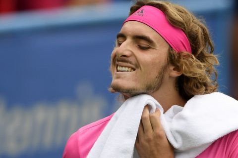 Stefanos Tsitsipas, of Greece, wipes his face in his match against David Goffin, of Belgium, during the Citi Open tennis tournament, Friday, Aug. 3, 2018, in Washington. (AP Photo/Nick Wass)