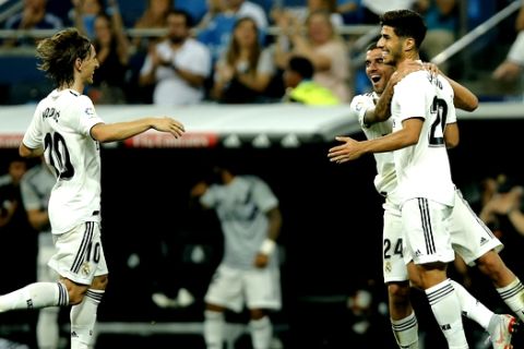 Real midfielder Marco Asensio, right, celebrates with Luka Modric, left and Dani Ceballos after scoring his side's first goal during a La Liga soccer match between Real Madrid and Espanyol at the Santiago Bernabeu stadium in Madrid, Spain, Saturday, Sept. 22, 2018. (AP Photo/Paul White)