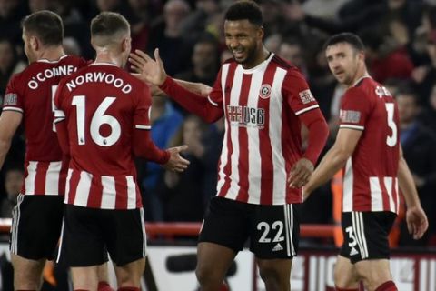 Sheffield United's Lys Moussett, center, celebrates with his teammates after scoring the opening goal during the English Premier League soccer match between Sheffield United and Arsenal at Bramall Lane in Sheffield, England, Monday, Oct. 21, 2019. (AP Photo/Rui Vieira)