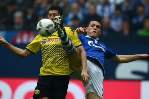 Schalke's Greek defender Kyriakos Papadopoulos (R) and Dortmund's Polish striker Robert Lewandowski vie for the ball during the German first division Bundesliga football match FC Schalke 04 vs Borussia Dortmund in the German city of Gelsenkirchen on April 14, 2012.  AFP PHOTO / PATRIK STOLLARZ


+++ RESTRICTIONS / EMBARGO - DFL LIMITS THE USE OF IMAGES ON THE INTERNET TO 15 PICTURES (NO VIDEO-LIKE SEQUENCES) DURING THE MATCH AND PROHIBITS MOBILE (MMS) USE DURING AND FOR FURTHER TWO HOURS AFTER THE MATCH. FOR MORE INFORMATION CONTACT DFL. (Photo credit should read PATRIK STOLLARZ/AFP/Getty Images)