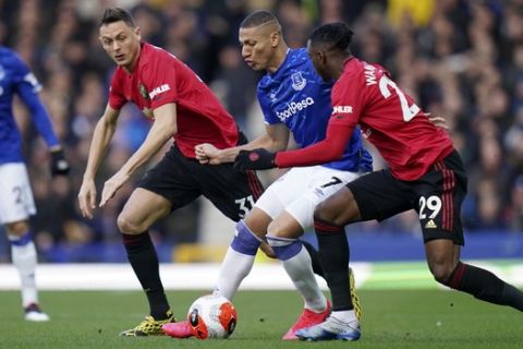 Everton's Richarlison controls the ball between Manchester United's Nemanja Matic and Aaron Wan-Bissaka, right, during the English Premier League soccer match between Everton and Manchester United at Goodison Park in Liverpool, England, Sunday, March 1, 2020. (AP Photo/Jon Super)