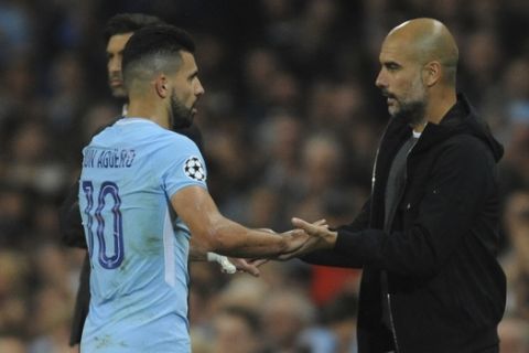 Manchester City head coach Pep Guardiola touches hands with Manchester City's Sergio Aguero as he is substituted during the Champions League Group F soccer match between Manchester City and Shakhtar Donetsk at Etihad stadium, Manchester, England, Tuesday, Sept. 26, 2017. (AP Photo/Rui Vieira)