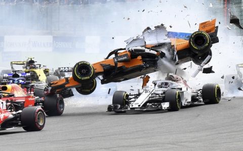 Mclaren driver Fernando Alonso of Spain, top, goes over the top of Sauber driver Charles Leclerc of Monaco as they are involved in a crash at the start of the Belgian Formula One Grand Prix in Spa-Francorchamps, Belgium, Sunday, Aug. 26, 2018. (AP Photo/Geert Vanden Wijngaert)