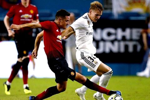 Manchester United midfielder Ander Herrera, front left, takes control of the ball from Real Madrid forward Martin Odegaard during the second half of an International Champions Cup tournament soccer match Tuesday, July 31, 2018, in Miami Gardens, Fla. Manchester United defeated Real Madrid 2-1. (AP Photo/Brynn Anderson)