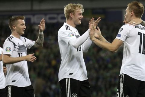 Germany's Marcel Halstenberg, right, celebrates after scoring the opening goal during the Euro 2020 group C qualifying soccer match between Northern Ireland and Germany at Windsor Park, Belfast, Northern Ireland, Monday, Sept. 9, 2019. (AP Photo/Peter Morrison)