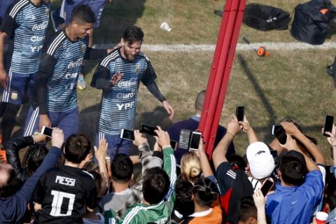 Argentina's Lionel Messi, center, waves to fans during a training session in Buenos Aires, Argentina, Sunday, May 27, 2018. Argentina will face Haiti on May 29 in an international friendly soccer match ahead of the FIFA Russia World Cup. (AP Photo/Natacha Pisarenko)