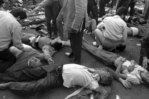 EDS: NOTE GRAPHIC CONTENT : File - In this May 29, 1985 file photo, victims of a wall collapse lay on the ground at the Heysel stadium in Brussels. Local authorities, families of victims and survivors marked the 30th anniversary of the Heysel stadium tragedy Friday, May 29, 2015 to commemorate the 39 football fans who died during hooligan riots at the 1985 European Cup final between Liverpool and Juventus. (AP Photo, File)