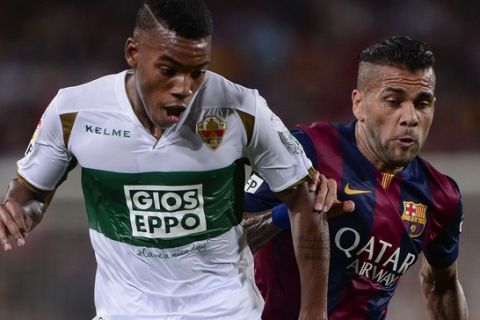 Barcelona's Brazilian defender Dani Alves (R) vies with Elche's midfielder Rodrigues during the Spanish league football match FC Barcelona vs Elche CF at the Camp Nou stadium in Barcelona on August 24, 2014. AFP PHOTO/ JOSEP LAGO        (Photo credit should read JOSEP LAGO/AFP/Getty Images)