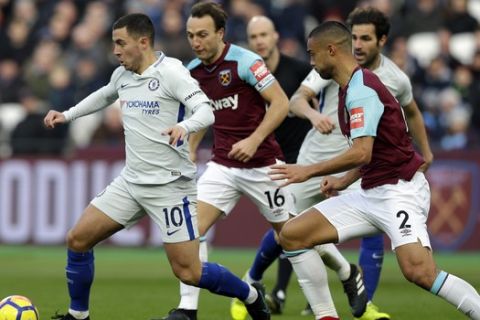 Chelsea's Eden Hazard, left, is chased by West Ham United's Mark Noble, center and West Ham United's Winston Reid, right, during the English Premier League soccer match between West Ham United and Chelsea at the London stadium in London, Saturday, Dec. 9, 2017. (AP Photo/Alastair Grant)