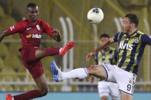 Fenerbahce's Mevlut Erdinc, right and Kayserispor's Bernard Mensah, jump or the ball during a Turkish Super League soccer match between Fenerbahce and Kayserispor in Istanbul, Friday, June 12, 2020. The Turkish Super Lig resumed its season on Friday without spectators after it had suspended games since March 20 due to the coronavirus pandemic, later than many other European leagues. (Erdem Sahin/Pool via AP)