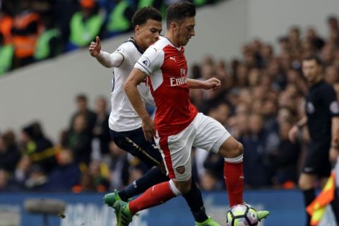 Arsenal's Mesut Ozil, right, battles for the ball with Tottenham Hotspur's Dele Alli during the English Premier League soccer match between Tottenham Hotspur and Arsenal at White Hart Lane in London, Sunday, April 30, 2017. (AP Photo/Alastair Grant)