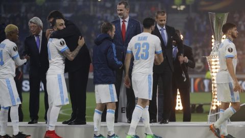 Marseille players pass the trophy after being greeted by Spain's King Felipe, center, having lost the Europa League Final soccer match between Marseille and Atletico Madrid at the Stade de Lyon in Decines, outside Lyon, France, Wednesday, May 16, 2018. (AP Photo/Francois Mori)