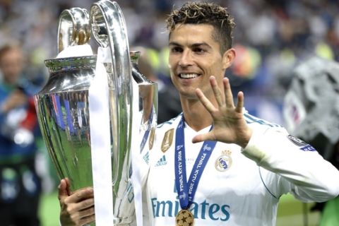 FILE - In this Saturday, May 26, 2018 file photo Real Madrid's Cristiano Ronaldo celebrates with the trophy after winning the Champions League Final soccer match between Real Madrid and Liverpool at the Olimpiyskiy Stadium in Kiev, Ukraine. (AP Photo/Pavel Golovkin)