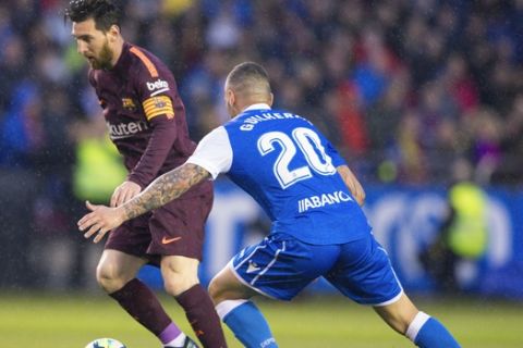 Barcelona's Lionel Messi, left,  fights for the ball with Deportivo's Guilherme during a Spanish La Liga soccer match between Deportivo and Barcelona at the Riazor stadium in A Coruna, Spain, Sunday, April 29, 2018. (AP Photo/Lalo R. Villar)