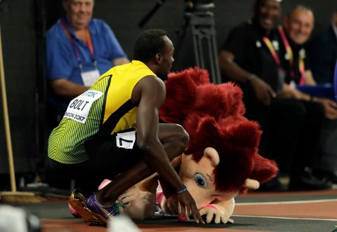 Hero, the tournament mascot, kneels in front of Jamaica's Usain Bolt after he completed a Men's 100 meters heat during the World Athletics Championships in London Friday, Aug. 4, 2017. (AP Photo/Tim Ireland)