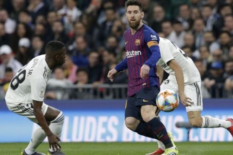 Barcelona forward Lionel Messi, center, eyes the ball during the Copa del Rey semifinal second leg soccer match between Real Madrid and FC Barcelona at the Bernabeu stadium in Madrid, Spain, Wednesday Feb. 27, 2019. (AP Photo/Andrea Comas)