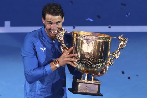 Rafael Nadal of Spain poses with the winner's trophy after beating Nick Kyrgios of Australia in the men's singles championship match in the China Open tennis tournament at the Diamond Court in Beijing, Sunday, Oct. 8, 2017. (AP Photo/Mark Schiefelbein)