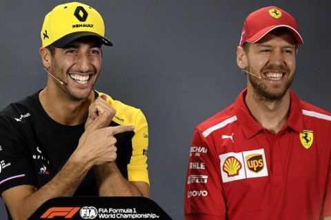 Renault driver Daniel Ricciardo, centre, of Australia jokes with Mercedes driver Lewis Hamilton, left, of Britain and Ferrari driver Sebastian Vettel, right, of Germany during the drivers press conference ahead of the Australian Formula One Grand Prix in Melbourne, Australia, Thursday, March 14, 2019. The season-opening Australian Grand Prix will be raced here on Sunday, March 17. (AP Photo/Andy Brownbill)