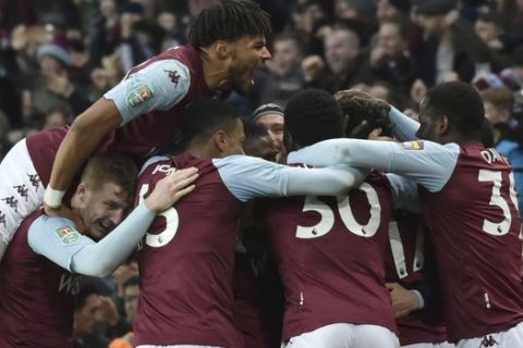 Aston Villa's Trezeguet is mobbed by his teammates after he scored his sides 2nd goal of the game during the English League Cup semifinal 2nd leg soccer match between Aston Villa and Leicester City and at the Villa'Park in Birmingham, England, Tuesday, Jan. 28, 2020. (AP Photo/Rui Vieira)