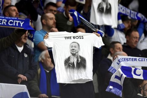 A Leicester City fan holds up a shirt in remembrance of Vichai Srivaddhanaprabha during the English Premier League soccer match between Cardiff City and Leicester City at the Cardiff City Stadium, Cardiff. Wales. Saturday Nov. 3, 2018. (Simon Galloway/PA via AP)