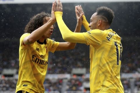Arsenal's Pierre-Emerick Aubameyang, right, celebrates scoring his side's first goal of the game with team mate Matteo Guendouzi,  during the English Premier League soccer match between Newcastle United and Arsenal, at St James' Park, in Newcastle, England, Sunday, Aug. 11, 2019. (Owen Humphreys/PA via AP)