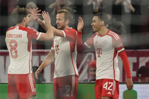 Bayern's Harry Kane, center, celebrates with his teammates after scoring his side's third goal during the Champions League round of 16 second leg soccer match between FC Bayern Munich and Lazio at the Allianz Arena stadium in Munich, Germany, Tuesday, March 5, 2024. (AP Photo/Matthias Schrader)
