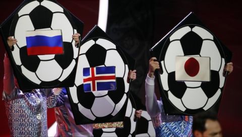 The flags of Russia, Iceland and Japan are held up on placards during the 2018 soccer World Cup draw in the Kremlin in Moscow, Friday Dec. 1, 2017. (AP Photo/Pavel Golovkin)