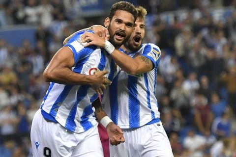 Real Sociedad's Martin Odegaard, back, goes to celebrates with teammates Willian Jose and Portu after Wiilian Jose scored the second goal of their during the Spanish La Liga soccer match between Real Sociedad and Alaves at Reale Arena stadium, in San Sebastian, northern Spain, Thursday, Sept. 26, 2019. (AP Photo/Alvaro Barrientos)