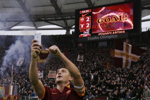 Roma's Francesco Totti celebrates with a selfie after scoring during a Serie A soccer match between Roma and Lazio at Rome's Olympic stadium, Sunday, Jan. 11, 2015. (AP Photo/Gregorio Borgia) ORG XMIT: GB147