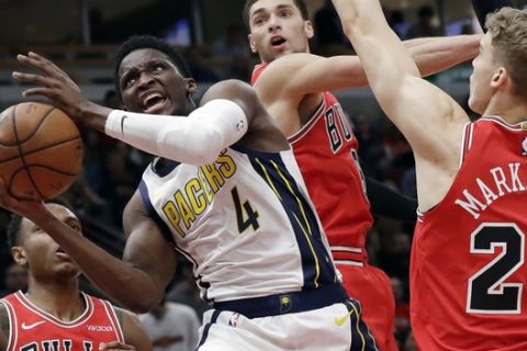 Indiana Pacers guard Victor Oladipo (4) drives to the basket against Chicago Bulls center Wendell Carter Jr., left, guard Zach LaVine, center, and guard Lauri Markkanen during the first half of an NBA basketball game Friday, Jan. 4, 2019, in Chicago. (AP Photo/Nam Y. Huh)