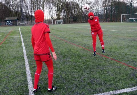 Afghani national soccer team player Shabnam Mabarz, seen from behind, watches as Khalida Popal, the former Afghanistan national women's team captain, heads the ball in Copenhagen on Tuesday, March 8, 2016. The new Afghanistan national women's soccer team uniform was revealed on Tuesday, featuring an integrated hijab. (AP Photos/Jan M. Olsen)