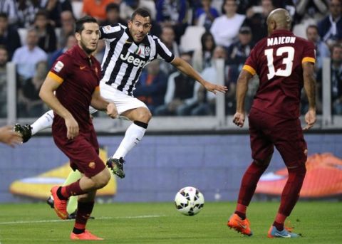 Juventus' Carlos Tevez kicks the ball as he is challenged by AS Roma's Konstantinos Manolas (L) and Maicon (R) during their Italian Serie A soccer match at Juventus Stadium in Turin October 5, 2014. REUTERS/Giorgio Perottino (ITALY - Tags: SPORT SOCCER)
