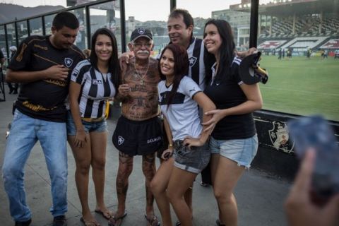 TO GO WITH AFP STORY by Javier Tovar
Brazilian football club Botafogo fan Delneri Martins Viana, a 69-year-old retired soldier, poses for pictures with other fans of the team, before a match at Sao Genario stadium in Rio de Janeiro, Brazil, on January 21, 2014. Delneri has 83 tattoos on his body dedicated to Botafogo and describes himself as the club's biggest fan.   AFP PHOTO / YASUYOSHI CHIBA