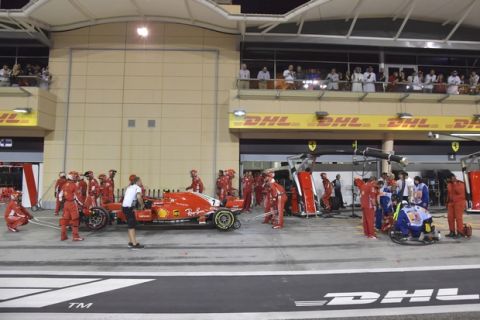 Ferrari mechanic Francesco, lies on the ground, right, after being bitted by Ferrari driver Kimi Raikkonen during a pit stop the Bahrain Formula One Grand Prix, at the Formula One Bahrain International Circuit in Sakhir, Bahrain, Sunday, April 8, 2018. (Pool/Giuseppe Cacace Via AP)