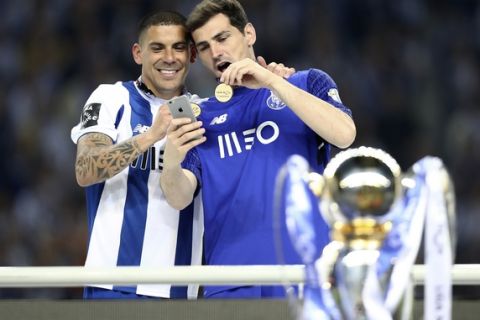 Porto goalkeeper Iker Casillas and teammate Maxi Pereira, left, take a selfie with their medals at the end of the Portuguese league soccer match between FC Porto and Feirense at the Dragao stadium in Porto, Portugal, Sunday, May 6, 2018. Porto clinched the league title Saturday night, two rounds before the end, when Benfica and Sporting CP tied 0-0 in their Lisbon derby. (AP Photo/Luis Vieira)