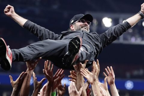 Liverpool coach Juergen Klopp is thrown into the air by player after winning the Champions League final soccer match between Tottenham Hotspur and Liverpool at the Wanda Metropolitano Stadium in Madrid, Saturday, June 1, 2019. (AP Photo/Manu Fernandez)
