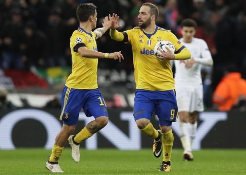 Juventus' Gonzalo Higuain, right, celebrates with his teammate Paulo Dybala after scoring, during the Champions League, round of 16, second-leg soccer match between Juventus and Tottenham Hotspur, at the Wembley Stadium in London, Wednesday, March 7, 2018. (AP Photo/Kirsty Wigglesworth)