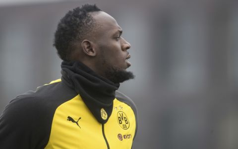 Jamaica's former sprinter Usain Bolt, center, takes part in a practice session of the Borussia Dortmund soccer squad in Dortmund, Germany, Friday, March 23, 2018.   ( Bernd Thissen/dpa via AP)